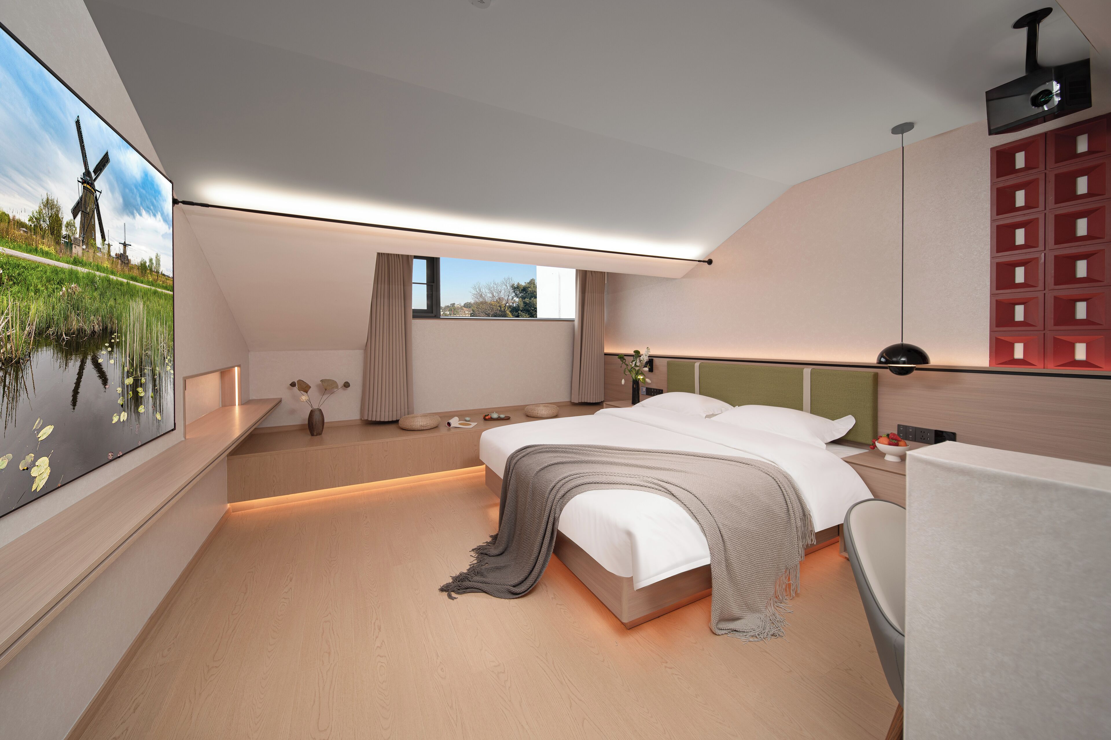 Quarto moderno com uma cama grande, mesas de cabeceira, escrivaninha, cadeira, janela e um quadro de moinhos.