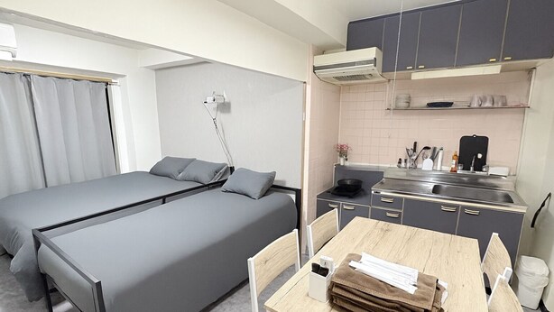 Una habitación pequeña con una cama individual y un rincón americano.