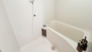 Un baño con bañera, ducha e inodoro.