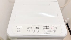 Una lavadora Panasonic blanca de 5.0, con panel de control y cable de alimentación.