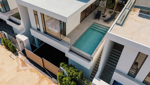 A modern multi-story building with a rooftop pool, large windows, and outdoor seating. - Elegant Aileen 3 Bedroom Pool Villa Naithon (Sa Khu)