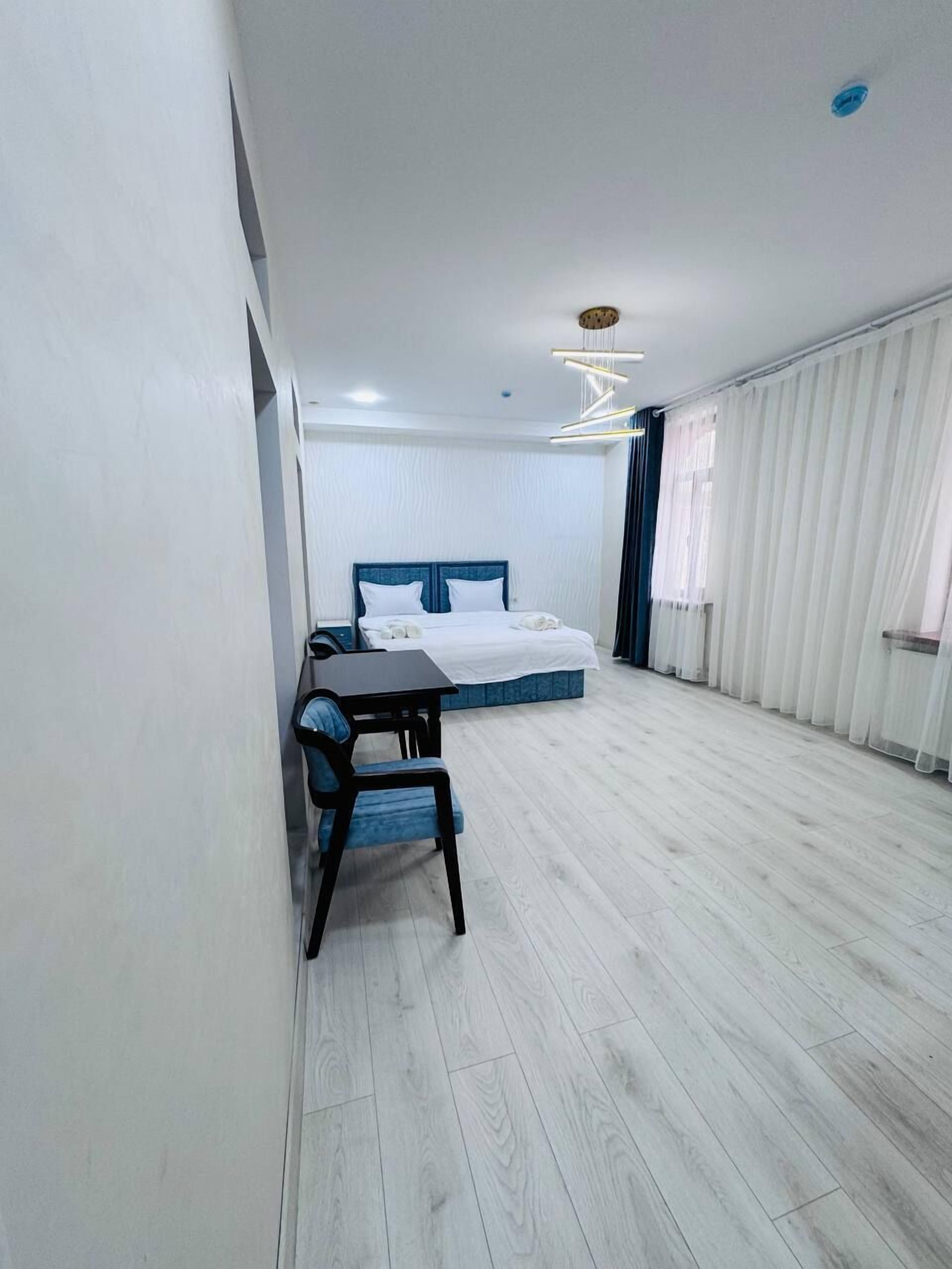 Une chambre d’hôtel moderne, dotée d’un grand lit, d’un bureau et d’une chaise.