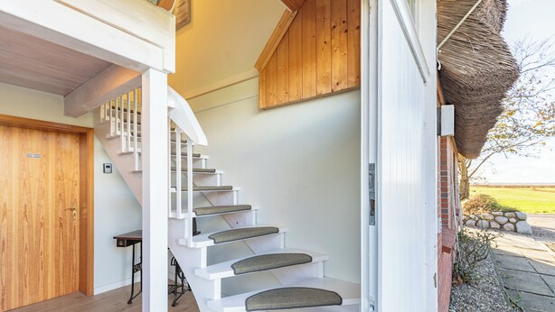 A white staircase with cushioned steps leading to a wooden door. - Vacation apartment "Elsabea" in Husum-Schobüll for up to 4 people (Husum)