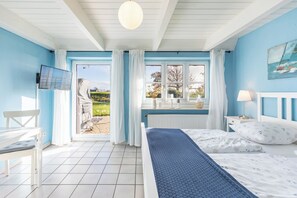 Une chambre à coucher avec un lit, une télévision, une fenêtre et une vue sur l’extérieur.