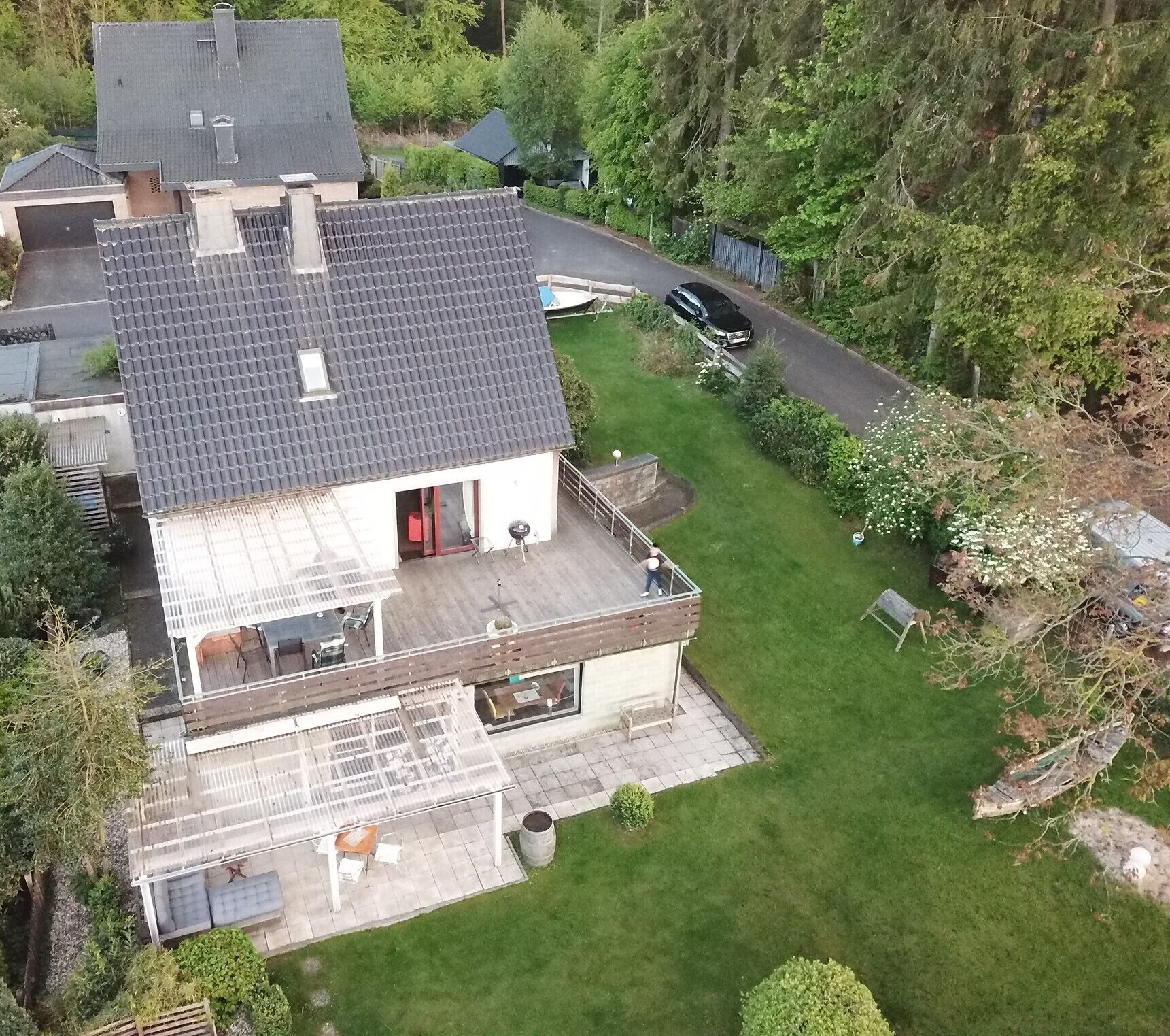 Ein zweigeschossiges Haus mit Terrasse, Garage und Auffahrt.
