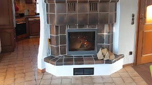 A fireplace with a tiled surround, a vent above it, and a door to the right. - Holiday Home 'Dell, 99qm' with Shared Pool, Shared Terrace and Wi-Fi (Möhnesee)