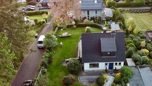 Un quartiere residenziale con case, una strada e una barca nel giardino.