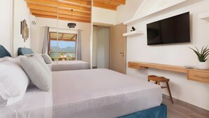 A modern bedroom with a large bed, a TV, a desk, and a window with a view. - Villa Logas Hill with Panoramic Sea Views, Wi-Fi and Air Conditioning (Peroulades)