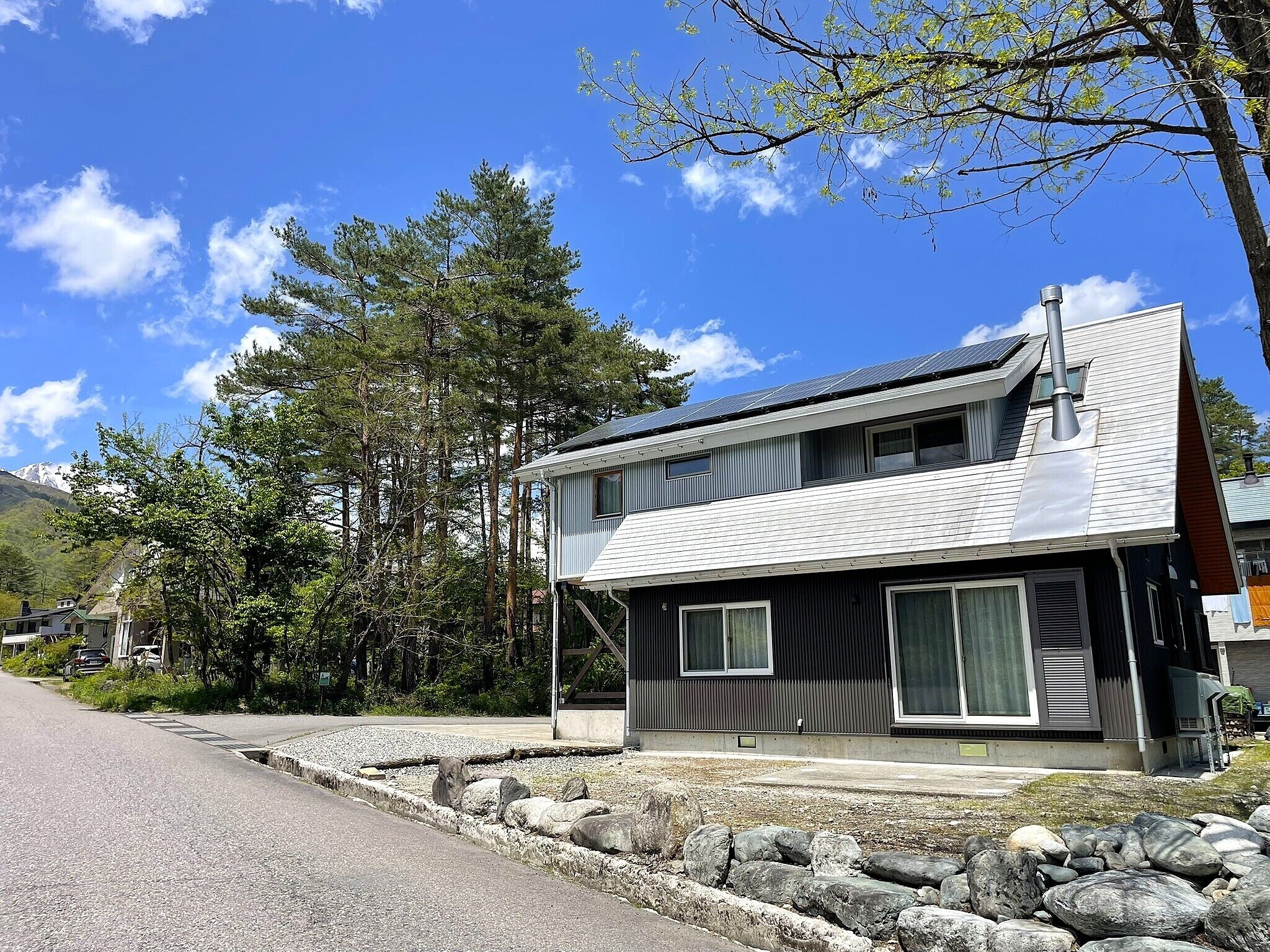 A two-story building with a modern design, large windows, and a stone foundation.