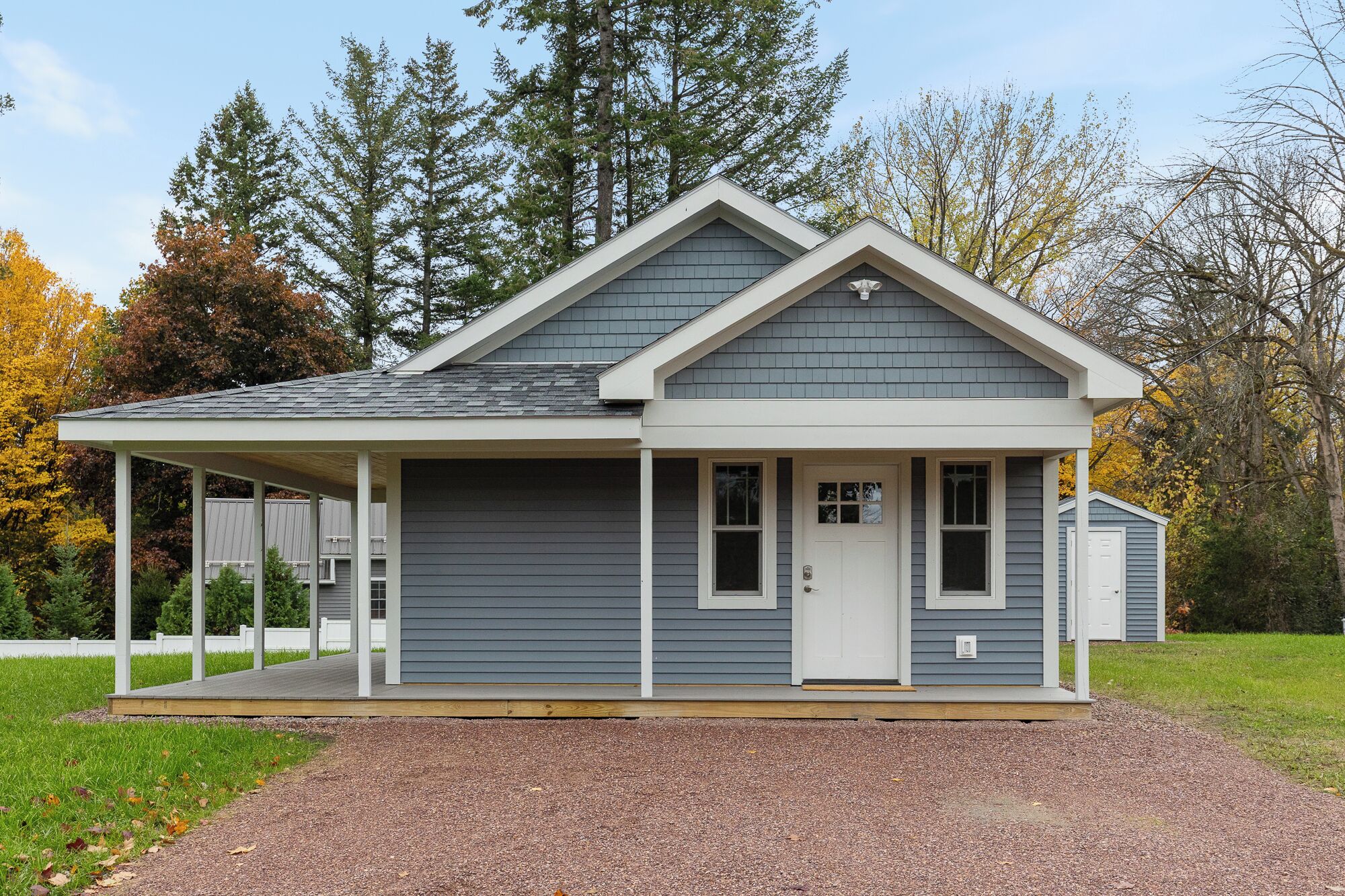 A single-story house with a gabled roof, a covered porch, and a front door.