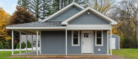 A single-story house with a gabled roof, a covered porch, and a front door.