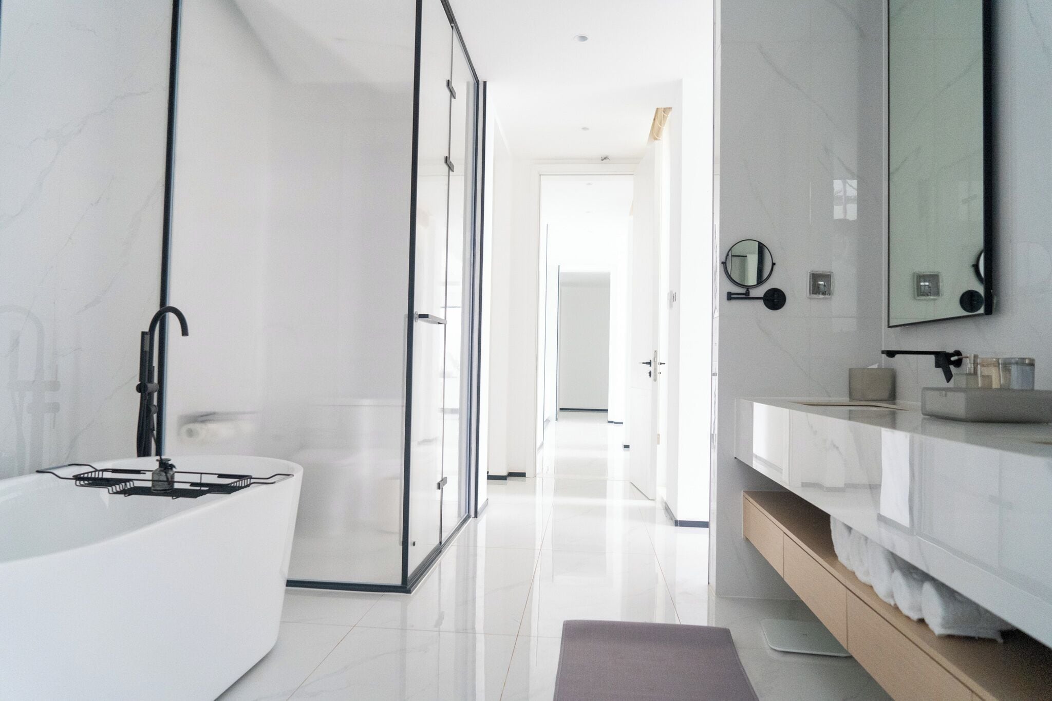 A modern bathroom with a large bathtub, a glass shower enclosure, and a vanity with a mirror.