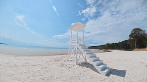 Una torre de salvavidas en una playa arenosa con cielos despejados.