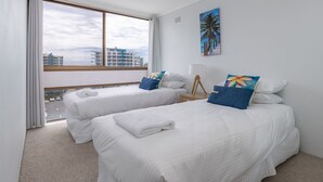 A hotel room with two beds, a large window, and a city view. - Forster Tower 64 in central Forster. (Forster)