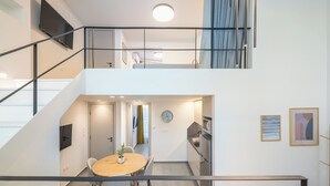 A modern apartment with a dining area, kitchen, and a staircase leading to a loft. - Athens Secluded Apartment A, Athens Secluded Apartments (Athens)