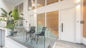 Um apartamento moderno com varanda, portas de vidro e área de jantar com cadeiras e mesa.