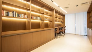 A modern library with wooden bookshelves and a desk area. - Brand New 1B With Burj Khalifa View in Business Bay (Dubai)