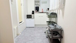 A narrow hallway with a kitchenette area featuring a microwave, coffee maker, and storage shelves. A shoe rack is visible on the right side. - XeroB HOUSE FLOLIA503 (osaka naniwa ward nanbanaka)