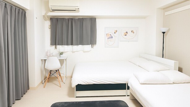 A modern bedroom with a bed, bedside table, chair, and an air conditioning unit. - XeroB HOUSE FLOLIA503 (osaka naniwa ward nanbanaka)