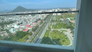A balcony with a city view, including roads, buildings, and a mountain.