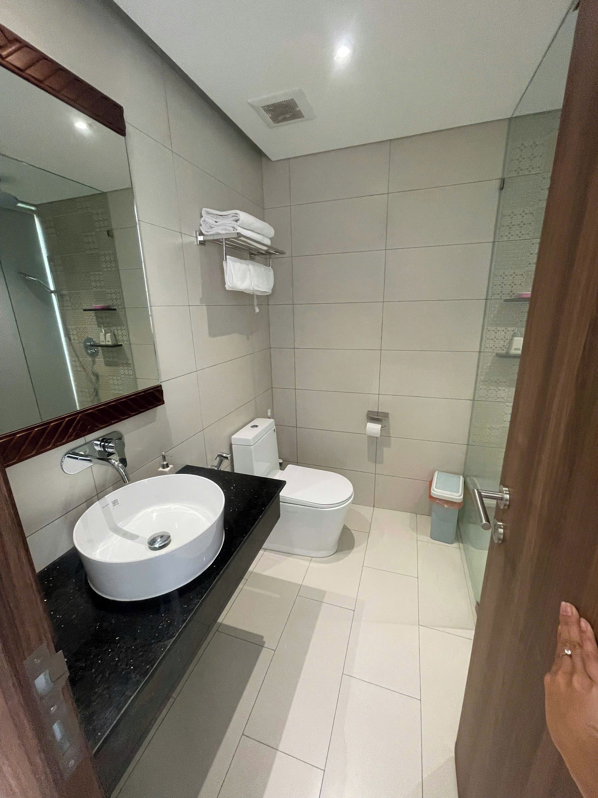Un bany modern amb un lavabo gran, vàter i mirall.