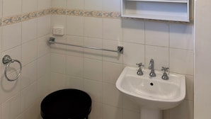 A bathroom with a white sink, a mirror, and a black toilet.