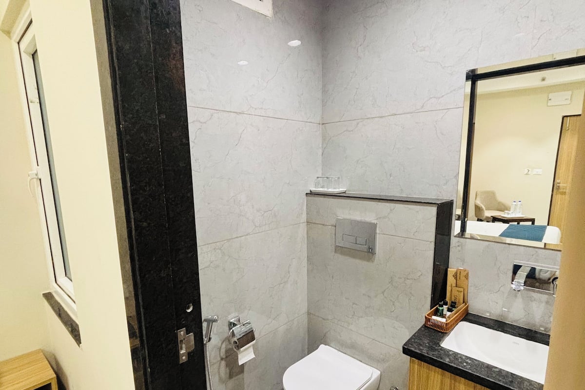A modern bathroom with a toilet, sink, and shower.