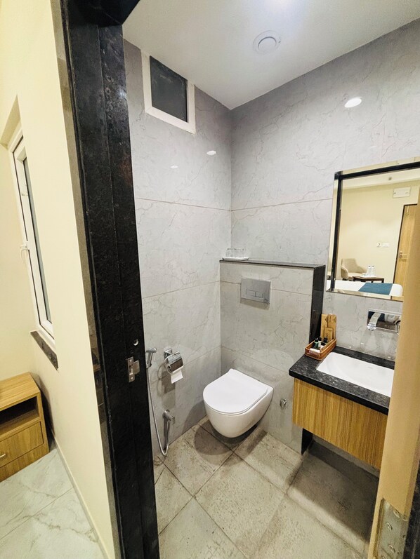 Un baño moderno con inodoro, lavamanos y ducha.