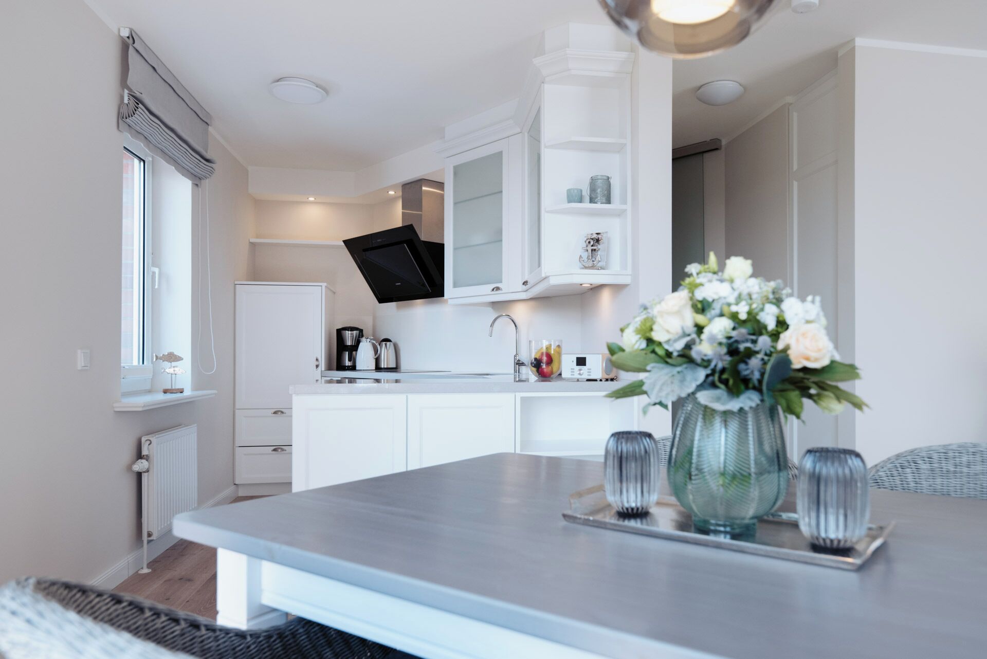 A modern kitchen with white cabinetry, a built-in microwave, and a coffee maker.
