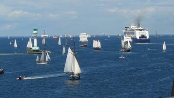A harbor with multiple sailboats and a large cruise ship.