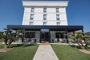 A hotel with a covered outdoor seating area and a clear sky.