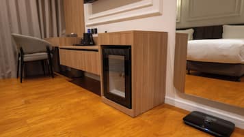 Habitación de hotel con escritorio de madera, una silla, una cama y un espejo grande.