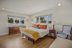 A bedroom with a bed, a dresser, a chair, and two windows with a view of trees. - Mountain-view Pagosa Springs house on five acres with four bedrooms, three baths, private hot tub, two fireplaces, chef's kitchen, and entertainment room; sleeps 7. (Pagosa Springs)