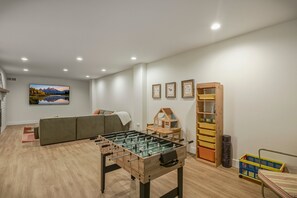 A living room with a foosball table, a sofa, a bookshelf, and a painting on the wall. - Mountain-view Pagosa Springs house on five acres with four bedrooms, three baths, private hot tub, two fireplaces, chef's kitchen, and entertainment room; sleeps 7. (Pagosa Springs)