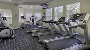 A fitness center with treadmills, elliptical machines, and a weight machine.