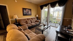 A living room with a sofa, a coffee table, a lamp, and a painting on the wall.