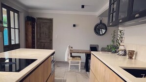 Una cocina moderna con armarios de madera, una isla central y un reloj en la pared.