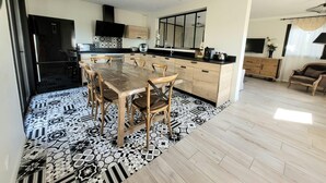 Una cocina moderna con una isla grande, armarios de madera y encimera negra.
