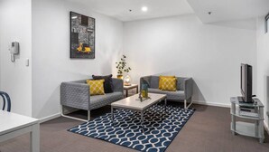 En moderne stue med to grå sofaer, et sofabord og et TV-møbel.