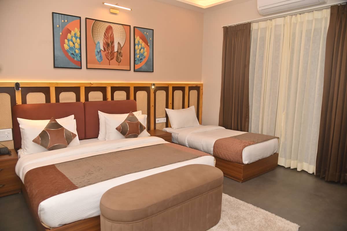 A hotel room with two beds, a wooden headboard, a large window with curtains, and wall art.
