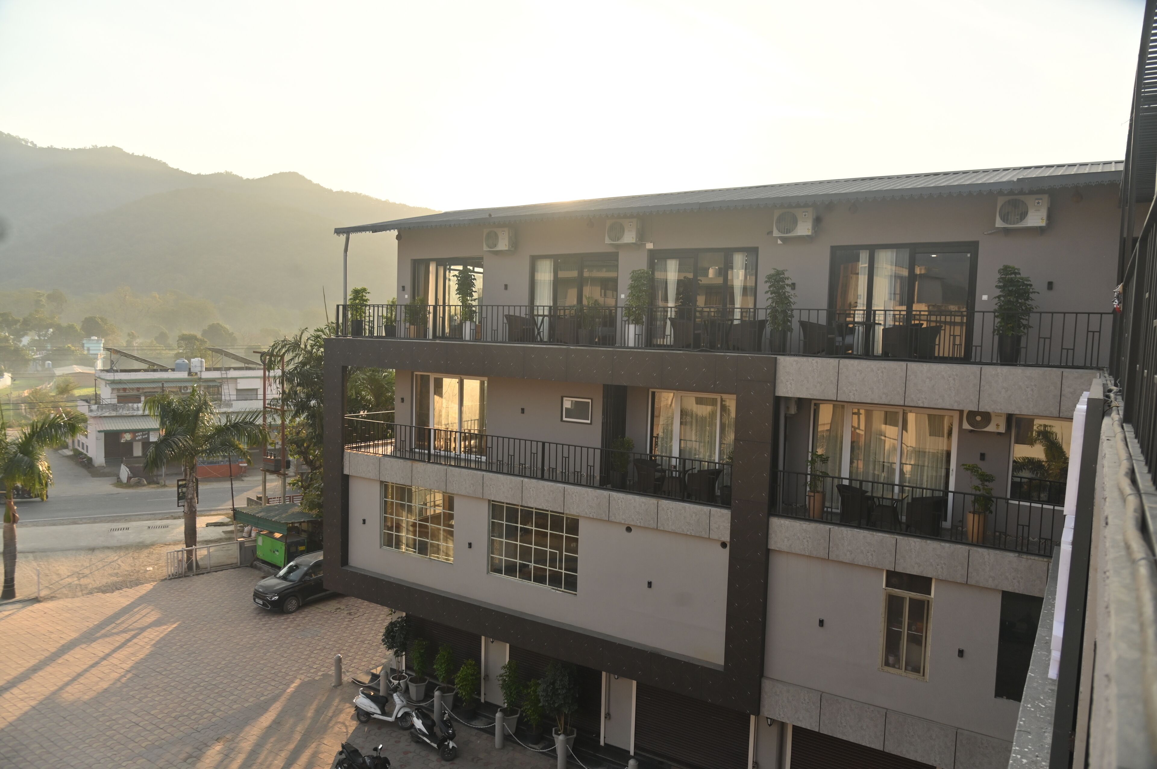 A multi-story building with balconies, large windows, and air conditioning units.