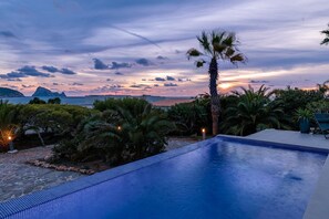 A swimming pool with a view of the sea and mountains at sunset. - Villa 'Casa Arola' with Sea Views, Wi-Fi and Air Conditioning (Sant Josep de sa Talaia)