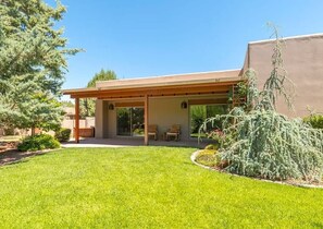 A modern house with a covered patio, a well-maintained lawn, and a variety of plants. - Peaceful Sedona Retreat, Views, Pool, Hot Tub! (Sedona)
