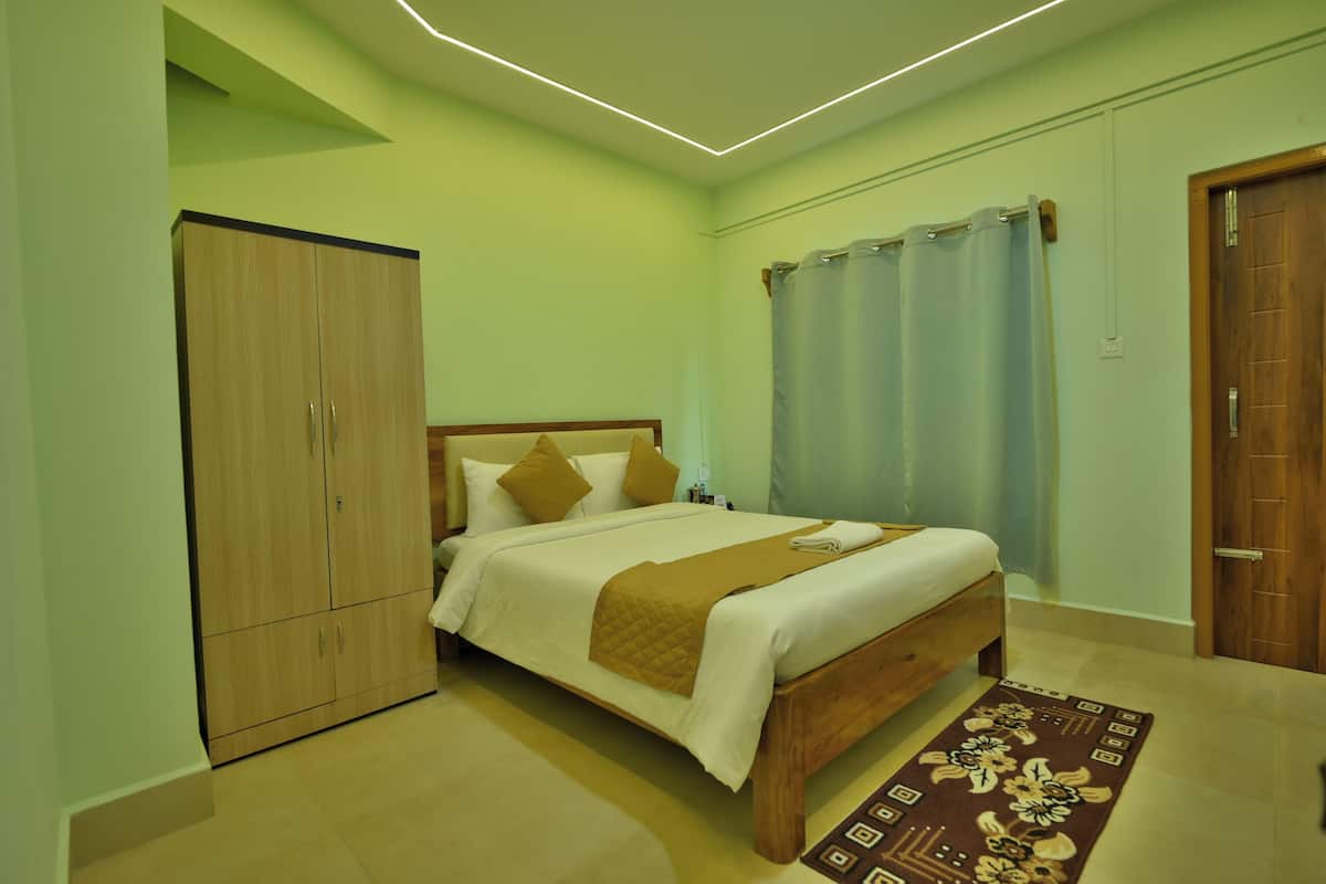 A bedroom with a bed, wardrobe, and curtains.