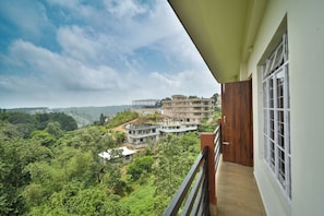 A balcony with a view of a residential area, a wooden door, and a window. - Kaizen Stay-Inn (Jowai)
