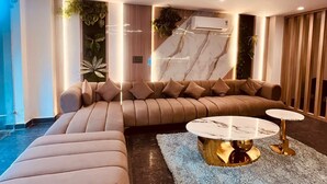 Ein modernes Wohnzimmer mit einer Eckcouch, einem runden Couchtisch und einem großen Fenster mit Blick.
