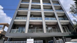 Ein mehrgeschossiges Gebäude mit modernem Design, mit Balkonen und großen Fenstern.
