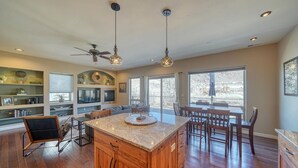 A spacious kitchen with a large island, wooden cabinets, and a dining area with chairs and a table. - Spacious 2BDRM, 2BA on the quiet edge of downtown Salida, Mountain Views, 2 blocks to shops (Salida)