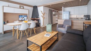 Een moderne woonkamer met een open haard, een eethoek en een keuken.