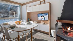 Een moderne keuken met een ingebouwde televisie, houten balken en een open haard.